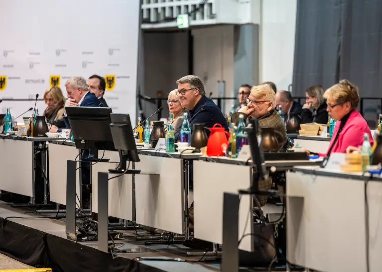Mehrere Personen sitzen an Tischen bei der Ratssitzung in Dortmund am 14. Dezember 2023