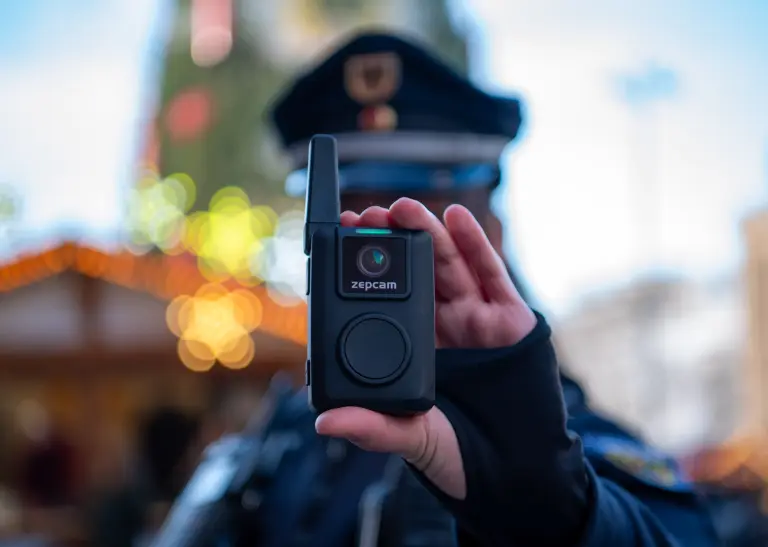 Kommunale Ordnungsdienst steht in der Dortmunder Weihnachtsstadt und hält die neuen Bodycam in der Hand. 