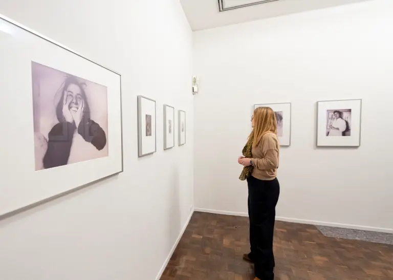 Eine Frau sieht sich Bilder in einer Ausstellung an.