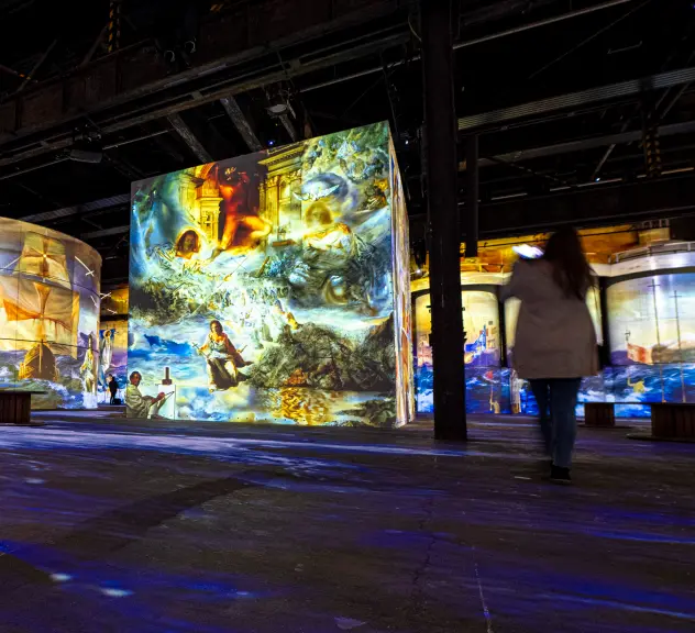 Ein Blick in die Ausstellung "Dali" im Phoenix des Lumieres. Bilder werden auf verschiedene Bauelemente sowie Boden und Wände projiziert.