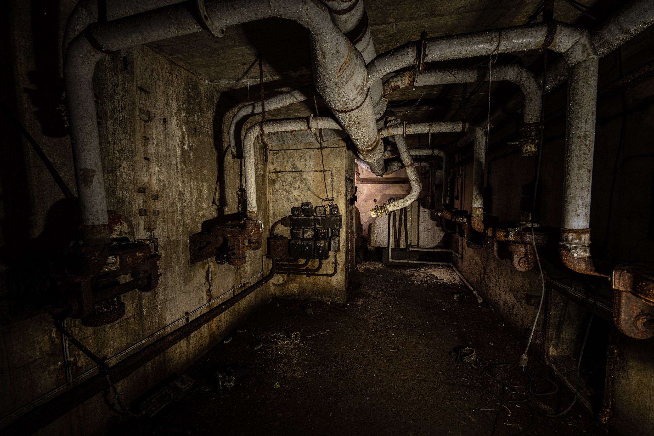 Ein Blick in den Heizungskeller. Rohre hängen von der Wand herunter.