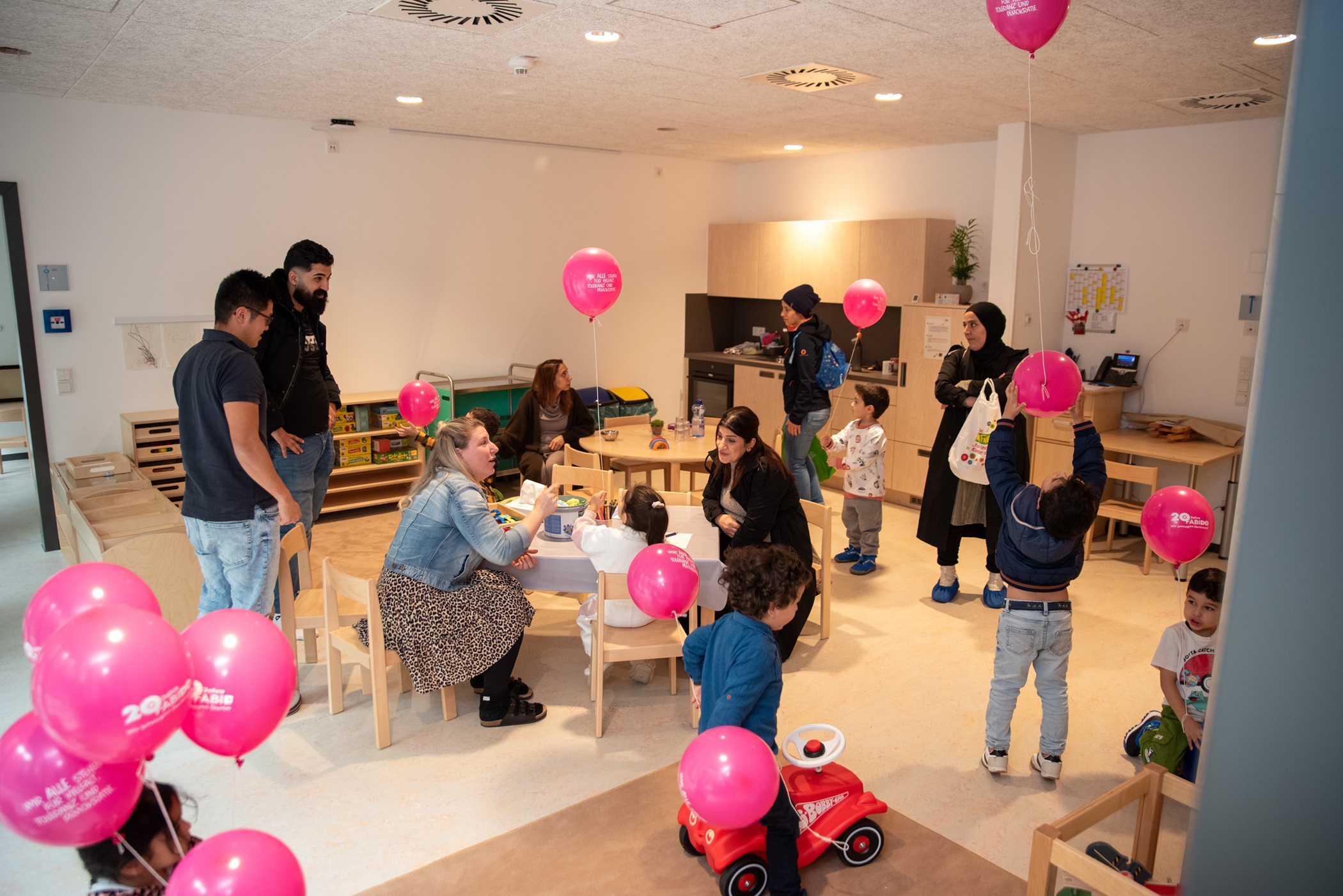 Einblick in den Gruppenraum mit Kindern und Erzieher*innen.