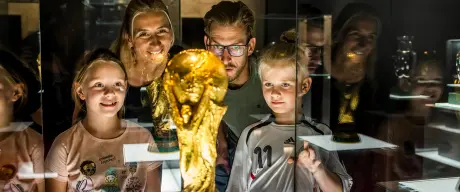 Familie bestaunt den WM-Pokal in der "Schatzkammer" des Fußballmuseum