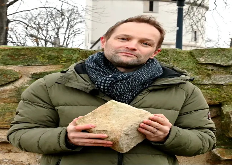 Stadtarchäologe Ingmar Luther hält einen Stadtmauerstein in den Händen