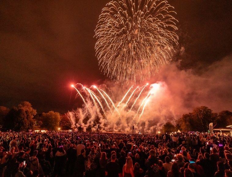 Das Feuerwerk beim Lichterfest im Westfalenpark Dortmund, im Vordergrund sind staunende Menschen.
