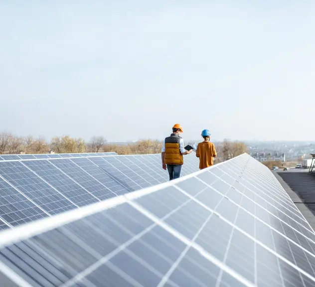 Zwei Menschen auf einem Dach mit Photovoltaikanlagen