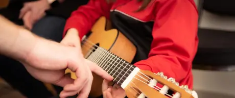 Musikschüler lernt Gitarre