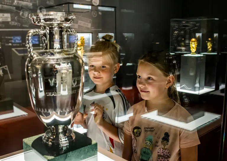 Zwei Mädchen bestaunen den EM-Pokal im Fußballmuseum