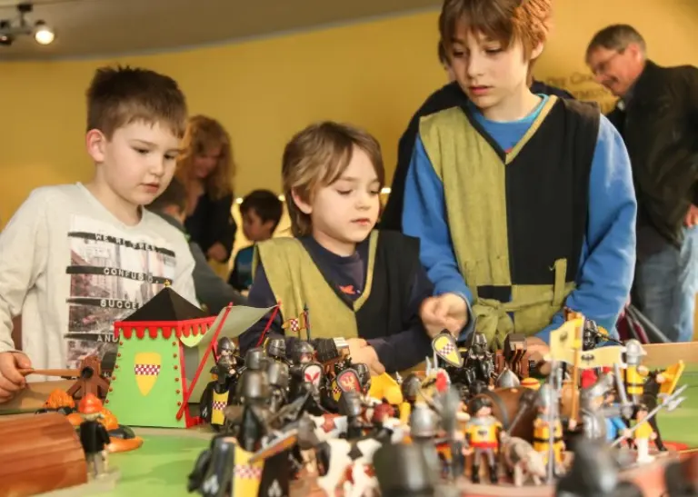 drei Kinder spielen die Dortmunder Stadtgeschichte mit Spielfiguren nach