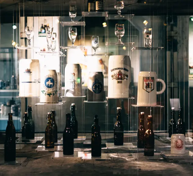 Verschiedene Biergläser vor einem Spiegel im Brauereimuseum in Dortmund.