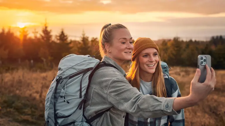 Zwei Frauen machen auf einer Wanderung in der Natur ein Selfie von sich