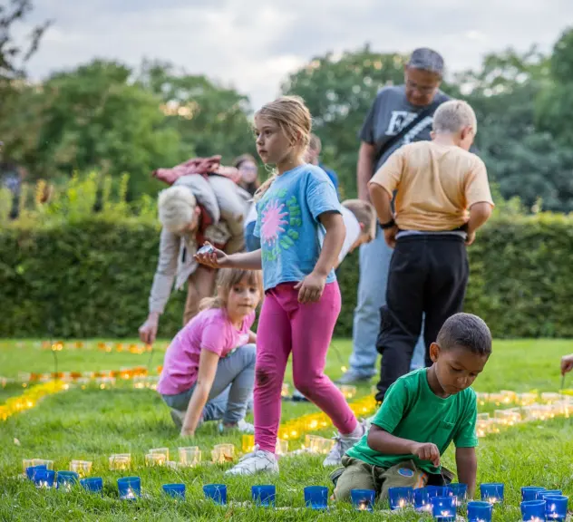 Kinder und Familien beim Gestalten von Kerzenarrangements im Westfalenpark, ein friedvolles Zusammensein in der Natur