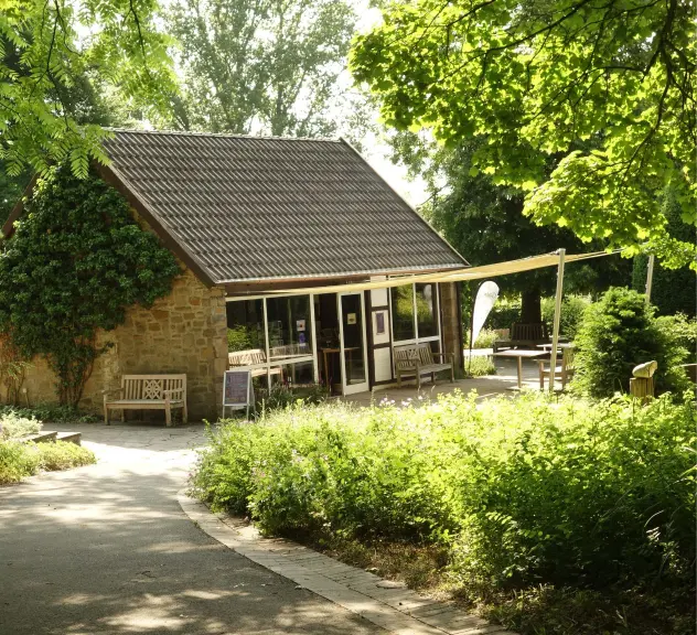 Die Galerie Torfhaus im Westfalenpark an einem sonnigen Tag, umgeben von grüner Vegetation, bietet einen einladenden Ort für Kunstliebhaber*innen
