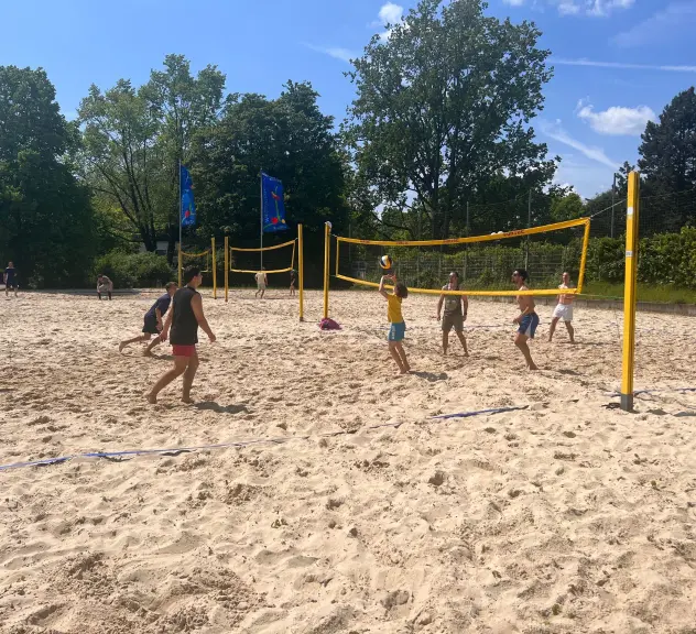 Besucher*innen genießen das Beachvolleyballspielen auf einem Sandplatz im Westfalenpark an einem sonnigen Tag, ein aktives Freizeitangebot für Jung und Alt