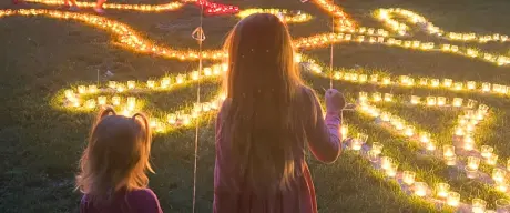Kinder beobachten beleuchtete Wegführung beim Lichterfest im Westfalenpark, mit Luftballons und Kerzenlicht in der Dämmerung