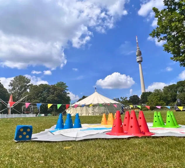 Spielaktivitäten für Familien auf einer Wiese im Westfalenpark während des Parksommers mit dem Dortmunder Fernsehturm im Hintergrund
