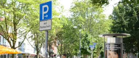 Bild eines blauen Parkschildes mit dem Hinweis "mit Parkschein" im Hintergrund das Kaiserviertel.