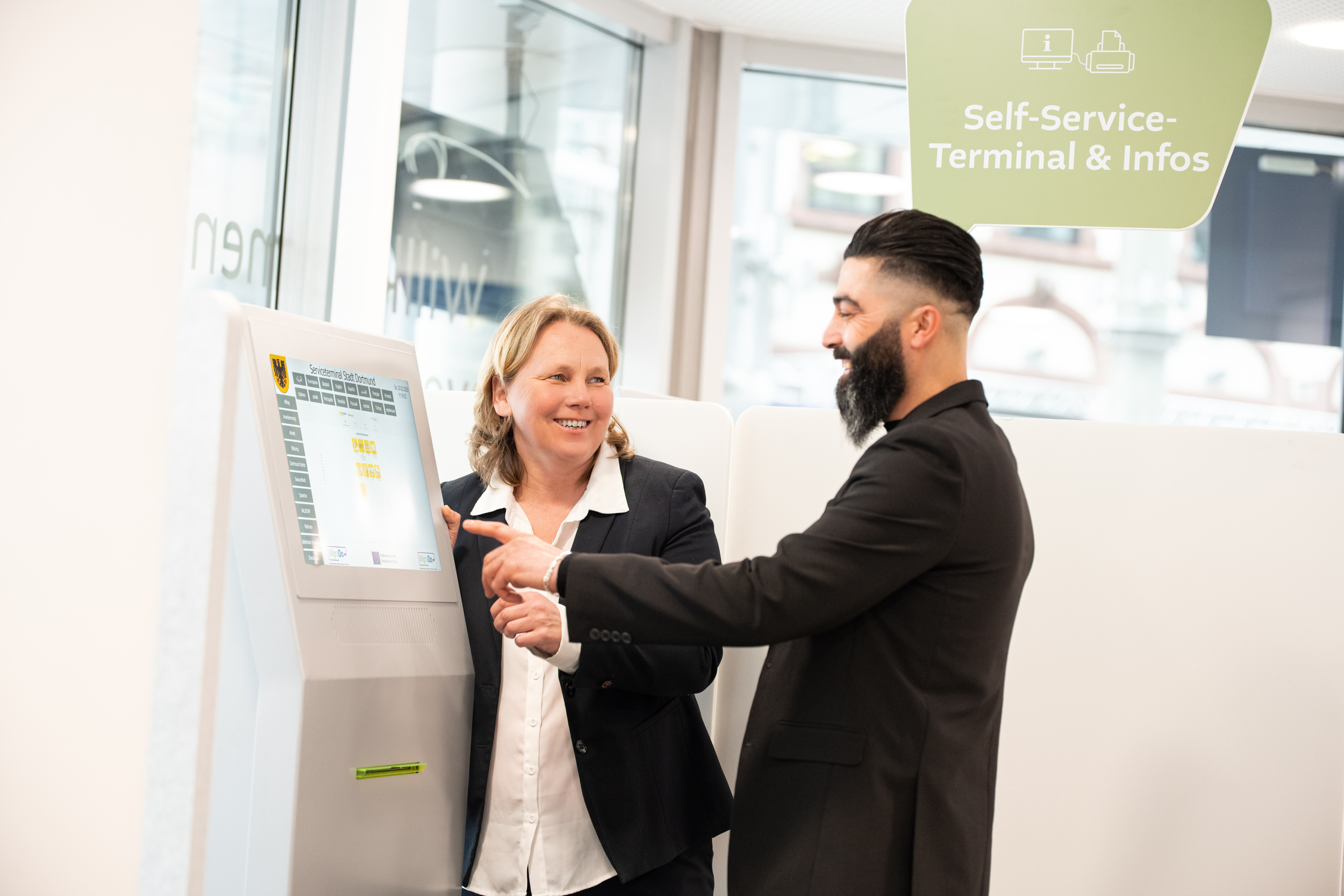 Zwei Personen an einem Digitalen Schalter, eine tippt etwas ein. 