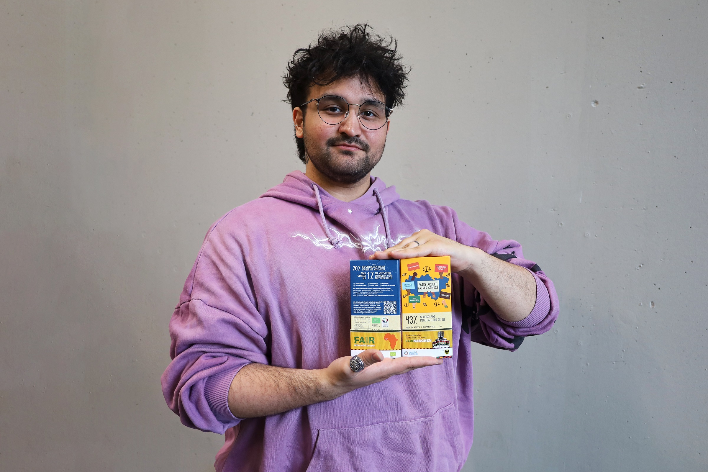 Yasin Hatipoglu präsentiert die faire Stadt Dortmund Schokolade mit seiner gestalteten Banderole.