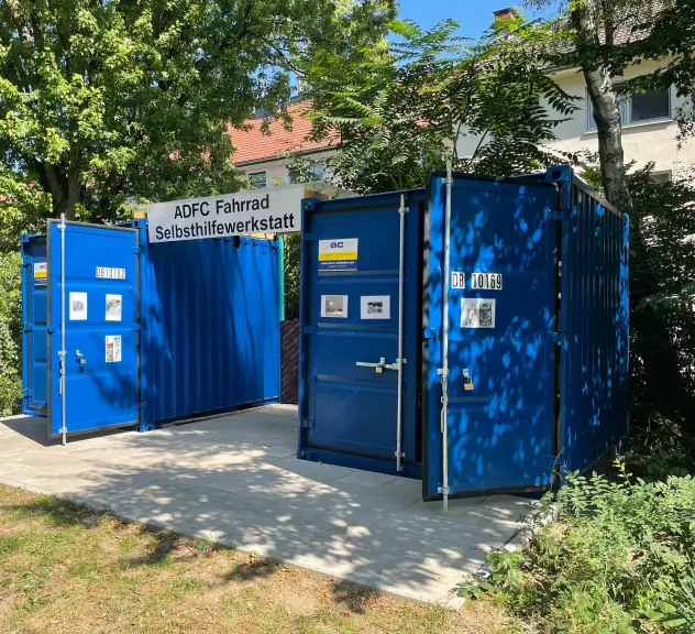 Ein blauer Container, der als ADFC Fahrrad Selbsthilfewerkstatt im AWO BunkerPlus Garten in der Nordstadt steht.