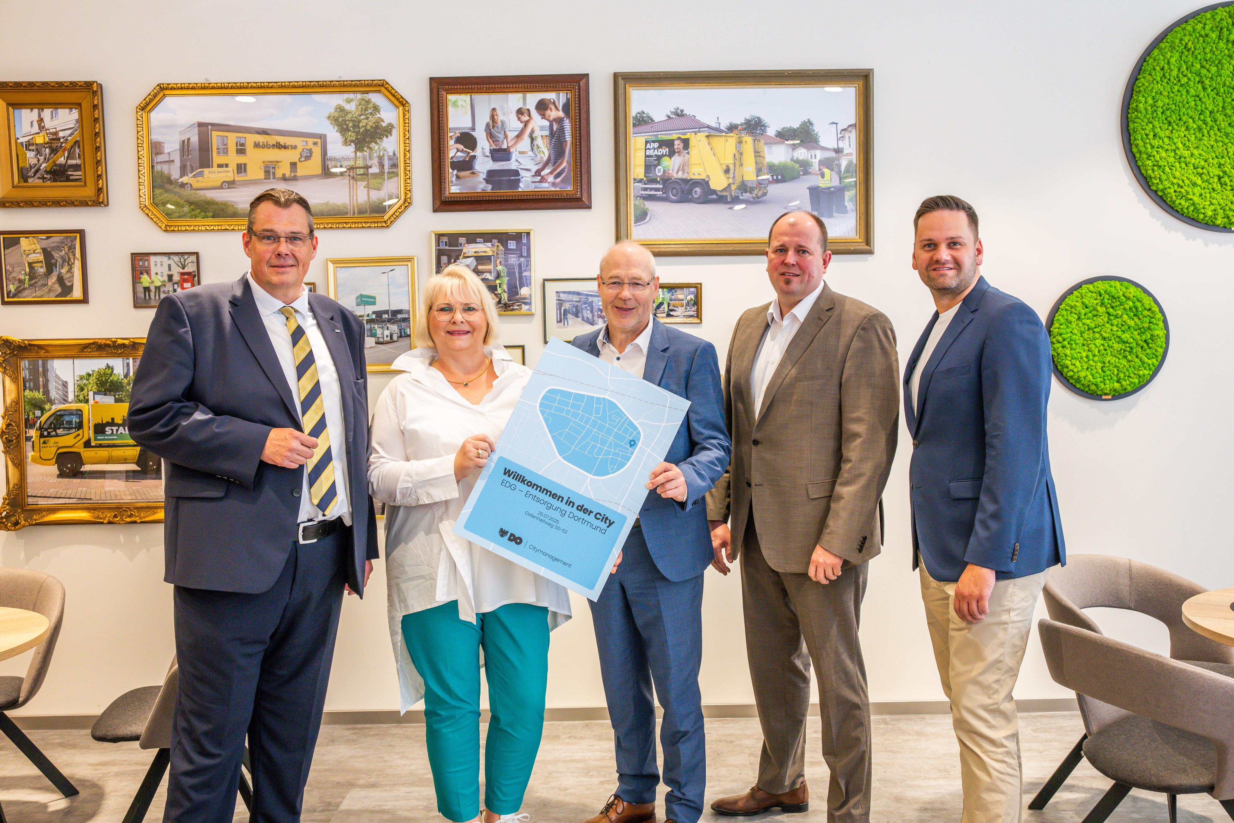 Foto von vier Männern und eine Frau, zwei von Ihnen halten eine stilisierte Karte der Dortmunder City in Händen. 