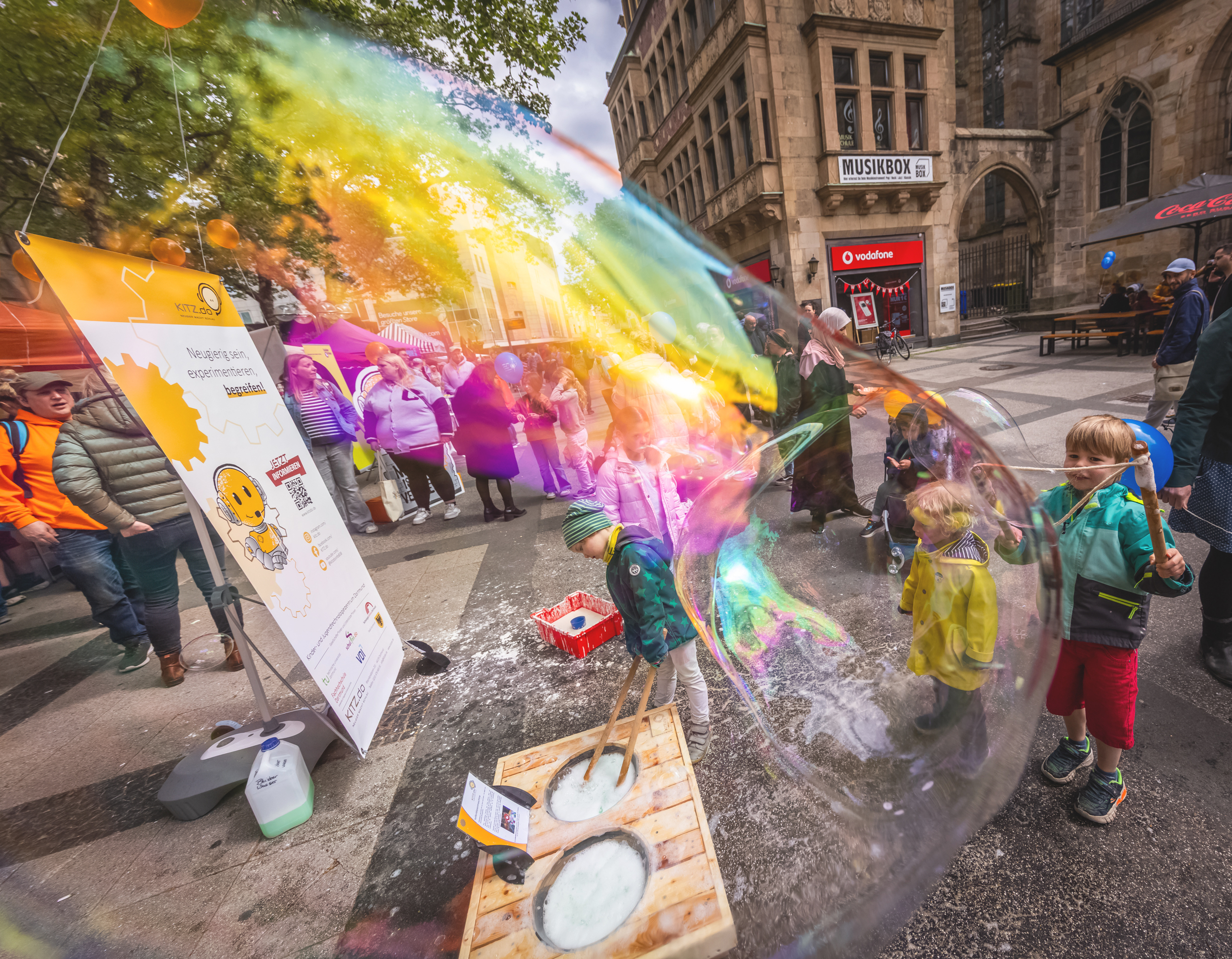Ein Jungen, der eine riesengroße Seifenblase macht. 