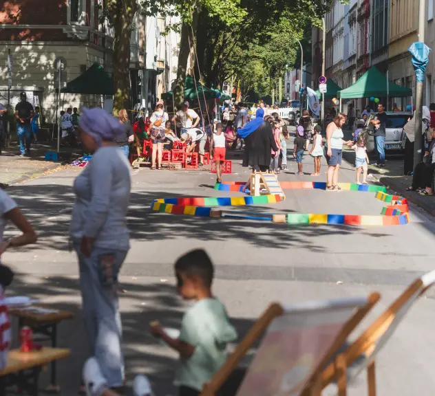 Menschen stehen und Kinder spielen auf einer Straße