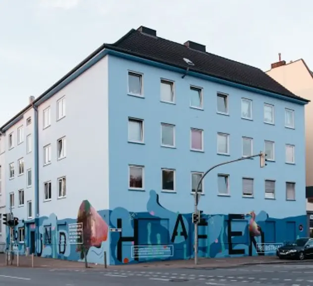 Ein blau angemaltes Haus mit der Aufschrift "Hafen"