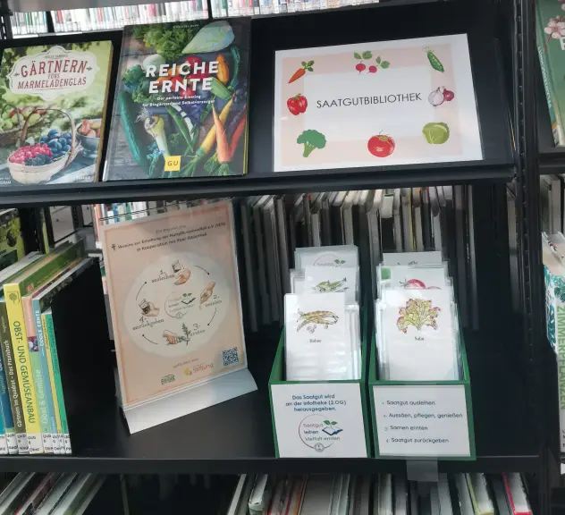 Ein Bücherregal mit Kochbüchern und einem Schild mit der Aufschrift "Saatgutbibliothek"