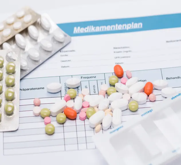 ein Medikationsplan und verschiedene Medikamentenpackungen liegen auf einem Tisch
