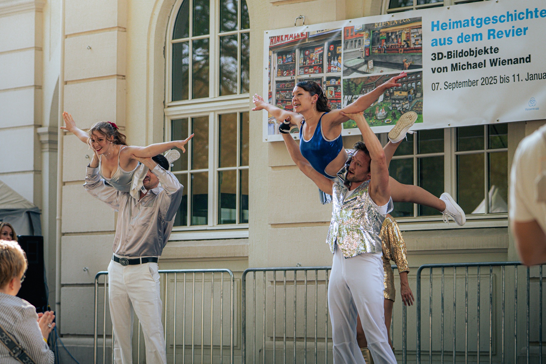 Rock'n'Roll Tänzer*innen des TSC Eintracht bei ihrem Auftritt vor dem Hoesch-Museum. Zwei Tanzpaare, die gerade eine Hebefigur zeigen.