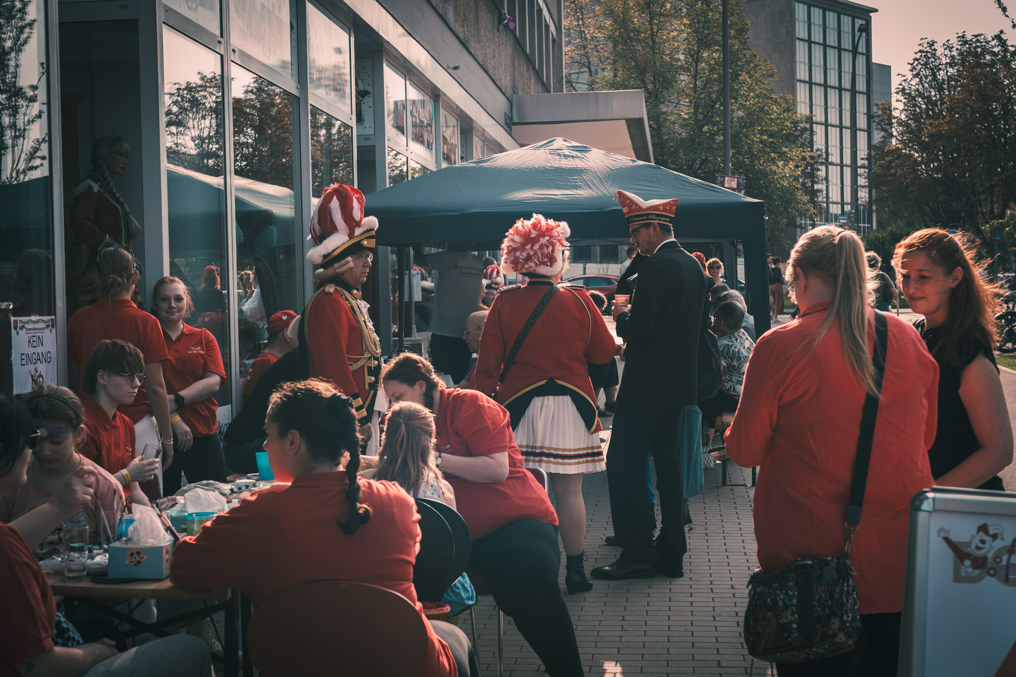 Stehende und Sitze Menschen in Karnevalsuniformen vor dem Karnevalsmuseum Dortmund.