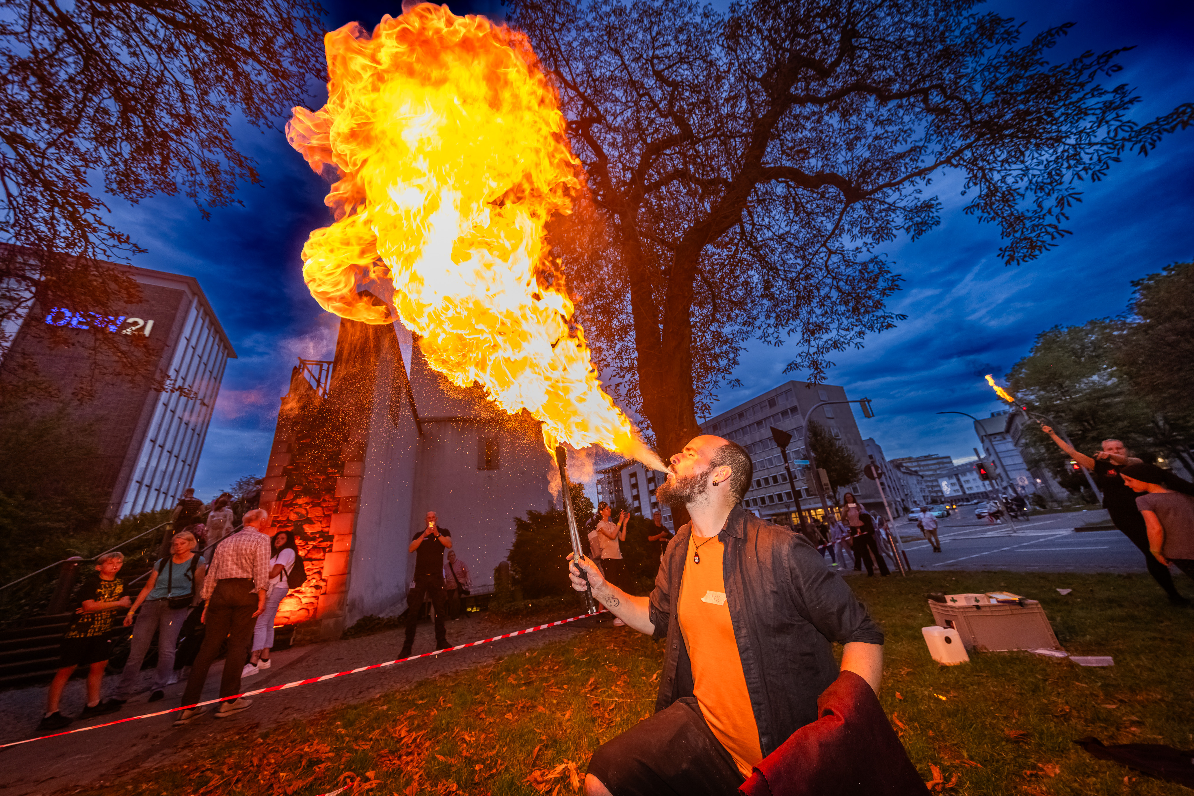 Ein feuerspuckender Mann auf der Wiese vor dem Kindermuseum Adlerturm