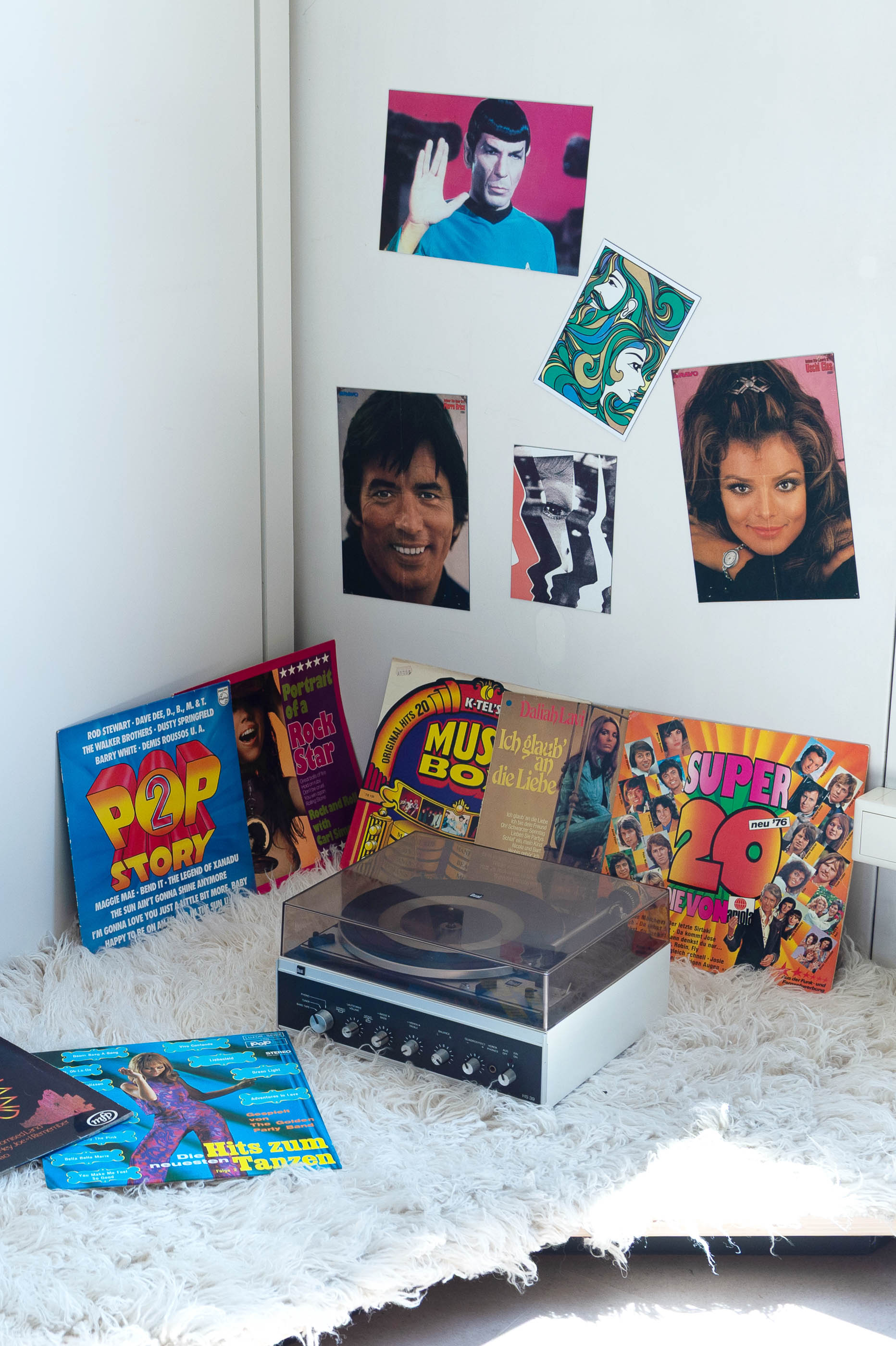 Schallplatten, Schallplattenspieler und Poster an der Wand