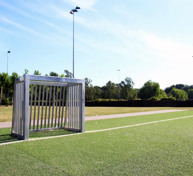 Ein kleines Fußballtor auf einem Kunstrasenfußballfeld.