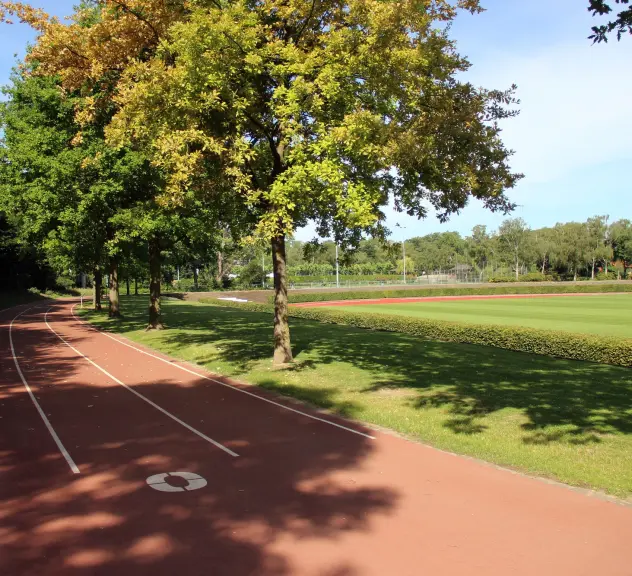 Eine Kunststofflaufbahn, Tartanbahn, die oberhalb des Fußballfelds im Hoeschpark lang geht.