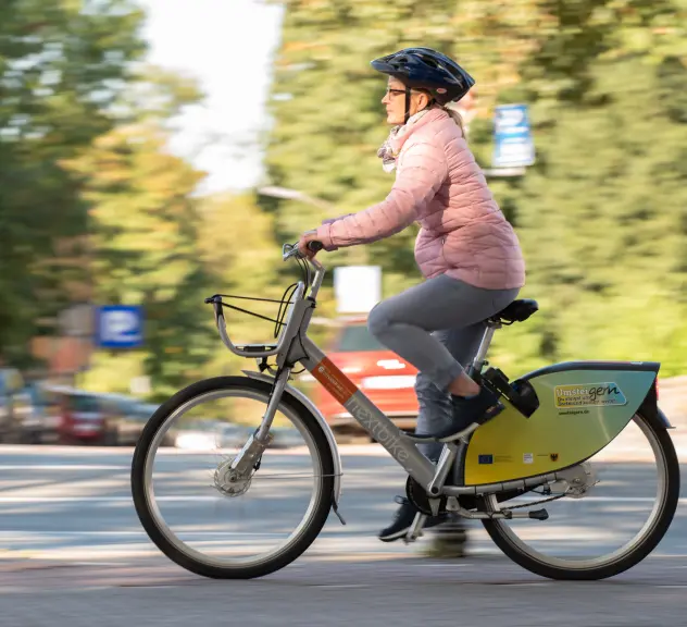 Eine Person fährt mit einem metropolradruhr Fahrrad eine Straße entlang.