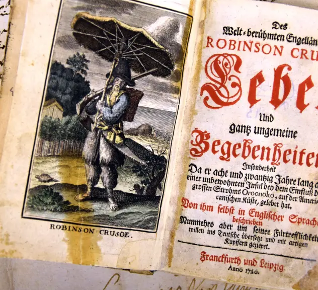 Aufgeklapptes Buch mit Text und der Zeichnung eines Mannes mit Sonnenschirm