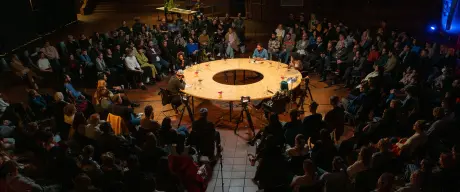 Ein runder Tisch umgeben von Publikum
